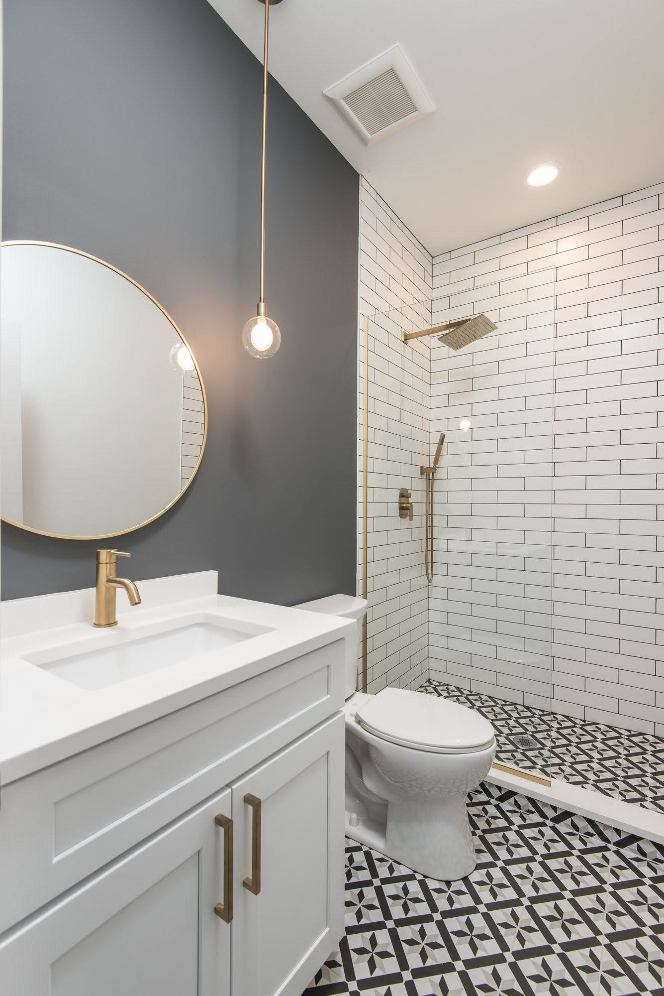 Bathroom vanity with round brass-framed mirror